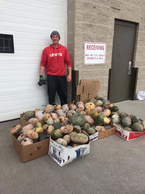 Planting for a Purpose Gardener posing with boxes of pumpkins.